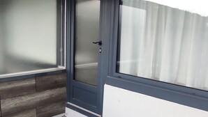 Un angolo di stanza con una porta, una finestra e un pavimento in legno.