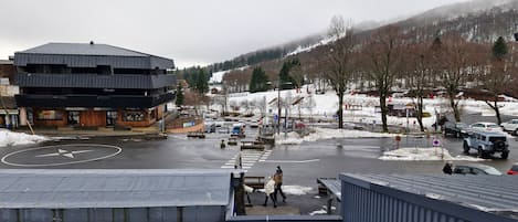 A modern building with a flat roof and a parking lot with snow.