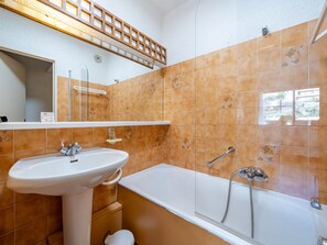 A bathroom with a white sink, a bathtub, and a shower.
