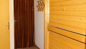 A hallway with a wooden door, a brown curtain, and a wooden wall decoration. - Les Gets: Charmant 2P+Coin Montagne, 5 Pers, Garage, Proche Centre et Pistes (Les Gets)