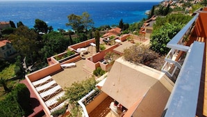 A rooftop terrace with outdoor seating and a view of the sea.