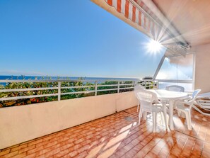 A terrace with a view of the sea, white chairs, and a table. - Studio for 6 people, sea view, Wi-Fi (Roquebrune-Cap-Martin)