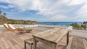 A wooden deck with lounge chairs and a table, overlooking a coastal view. - Villa Toschi beach front (TERTENIA)