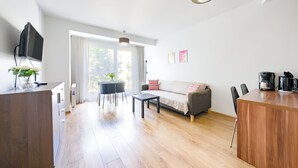 Ein modernes Wohnzimmer mit Sofa, Couchtisch und Essbereich.