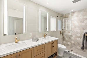 A modern bathroom with two sinks, a toilet, and a shower. - Pristine and Central 4-bedroom home perfect for elegant entertaining/relaxation (Coronado)