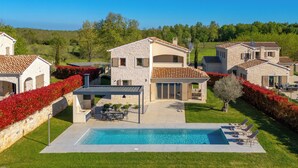 A residential property with a swimming pool, outdoor seating, and a well-maintained garden. - Sun  Spalato Villa Oblica (Jadruhi)