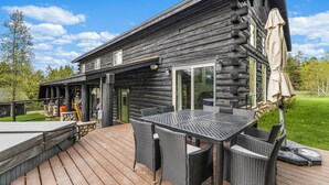 A log cabin with a deck, outdoor seating, and a covered patio area. - Black Fork Lodge - Beautiful log home on 2.5 acres with trailer parking and panoramic views (McCall)