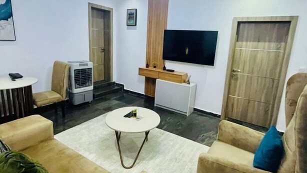 Una sala de estar moderna con un televisor de pantalla plana, una mesa de centro y asientos cómodos.