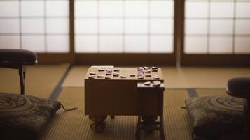 Une pièce avec un sol recouvert de tatamis, une table en tatami et des coussins.