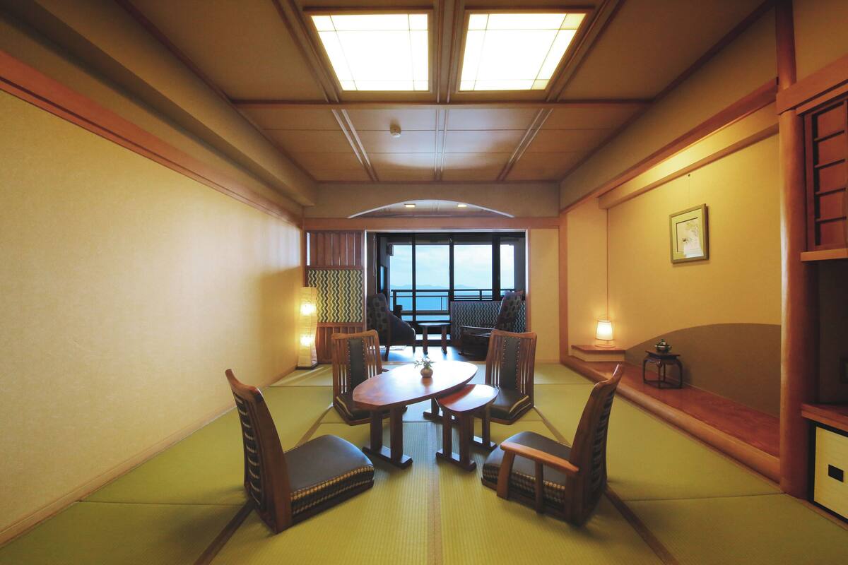 Ein traditioneller japanischer Raum mit Tatami-Boden, einem niedrigen Tisch und vier Stühlen.