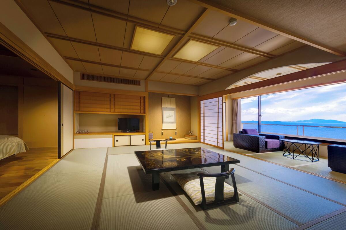 Ein traditioneller japanischer Raum mit Tatami-Böden, einem niedrigen Tisch und Blick aufs Meer.