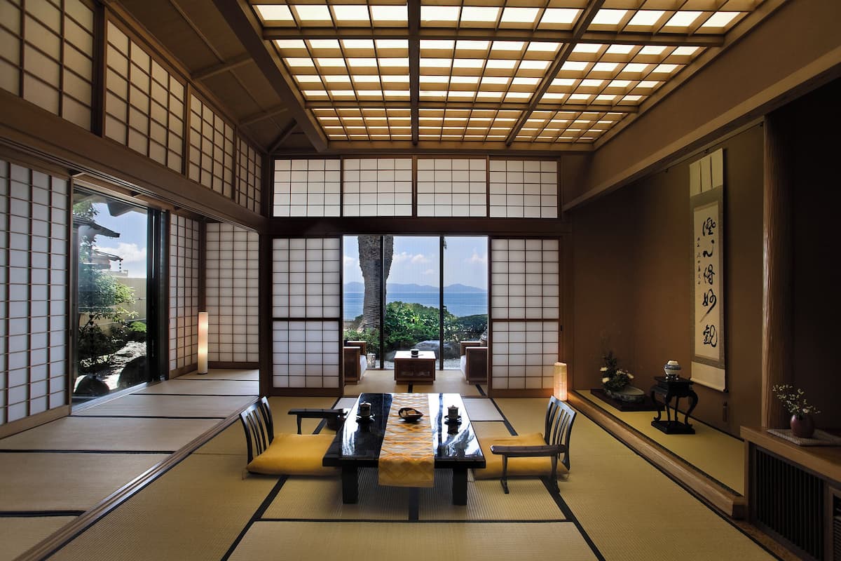 Ein traditioneller japanischer Raum mit Tatami-Böden, einem niedrigen Tisch und Blick ins Freie.