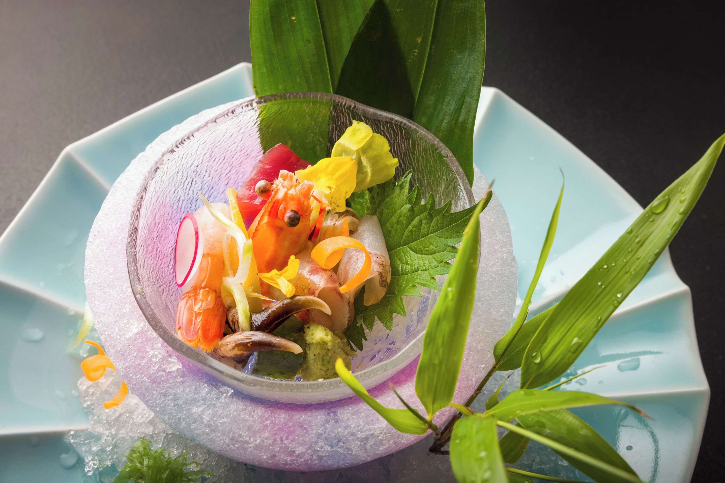 Un plato decorativo con comida colorida y hojas verdes.
