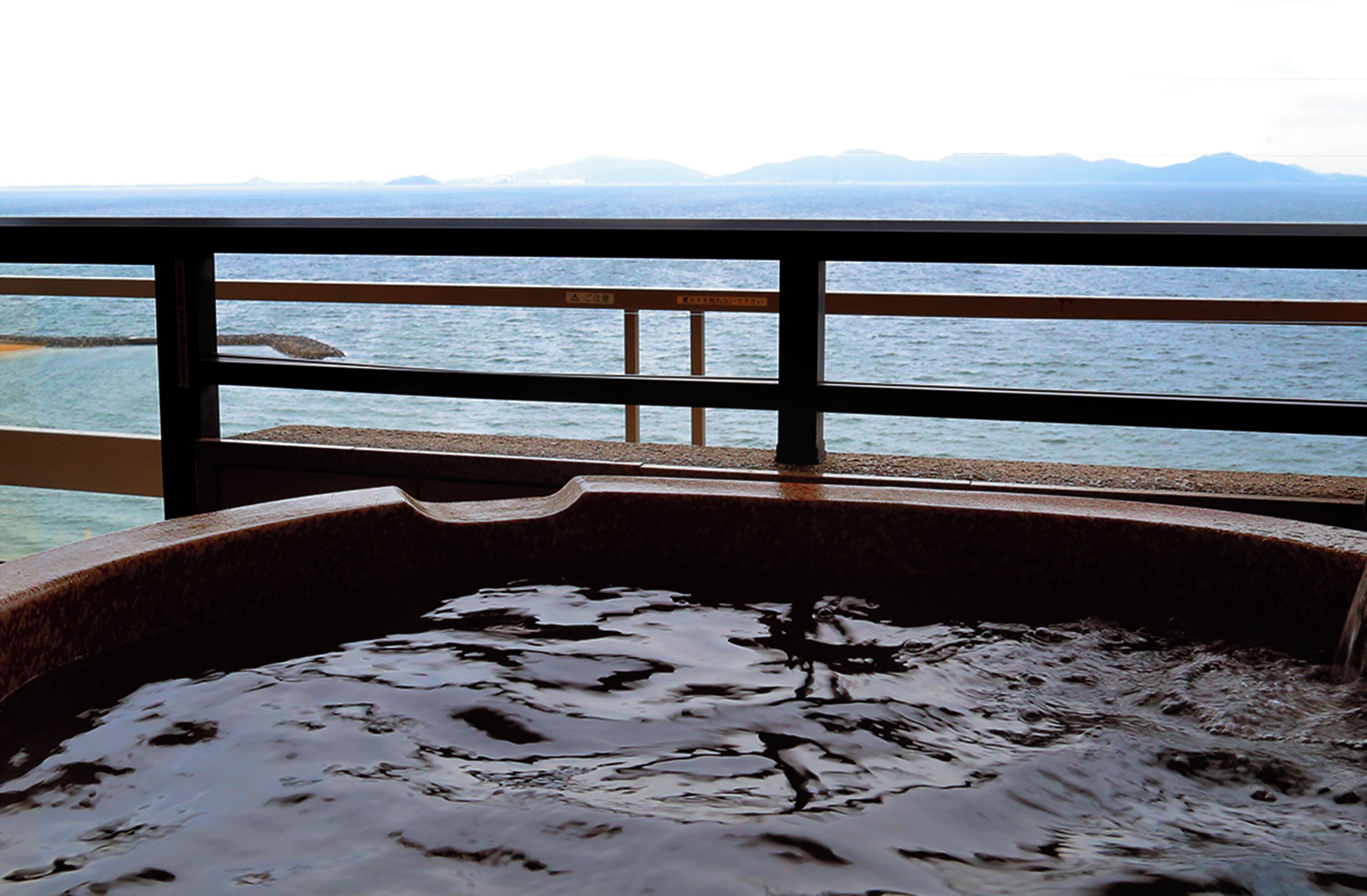 Una vasca idromassaggio con vista mare e montagne.