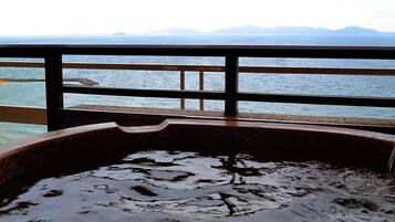 Una vasca idromassaggio con vista mare e montagne.
