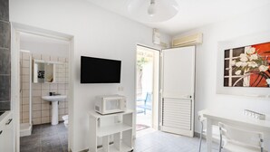 Une salle de bain moderne équipée d’un lavabo, de toilettes et d’un téléviseur à écran plat fixé au mur.