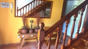 A wooden staircase with a handrail and a mirror above it.
