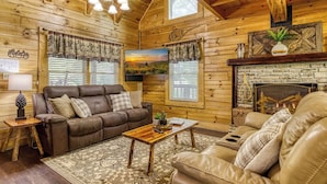 Ein gemütliches Holzhaus-Interieur mit einem braunen Ledersofa, einem Holztisch und einem Steinkamin.