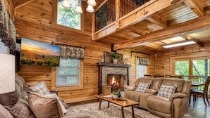 Ein gemütliches Ferienhaus-Interieur mit Kamin, Ledersofas und Essbereich.