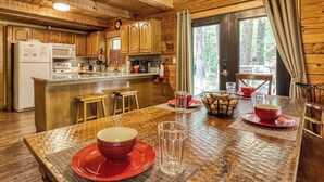 A wooden cabin interior with a kitchen, dining area, and a large window. - Hidden Mountain Dream, Lake View, Foosball, Hot Tub, Free Attraction Tickets!!! (Sevierville)