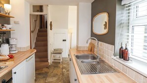A compact kitchen with a sink, a coffee maker, and a small dining area.