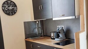 A compact kitchen with dark cabinets, a wooden countertop, a coffee maker, and a kettle. - between  carcassonne and narbonne with swimming pool (Capendu)