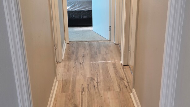 A narrow hallway with wooden flooring and white trim. - Charming 3-bedroom bungalow in pleasant Indianapolis with WiFi, AC, (Indianapolis)