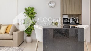 Una sala de estar moderna con un sofá, una planta en maceta, una mesa de centro y un reloj en la pared.