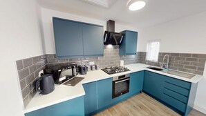 A modern kitchen with blue cabinets, a built-in oven, a gas stove, and a sink. - For Workers | 10 Mins to City | 5 TVs and Parking (Liverpool)