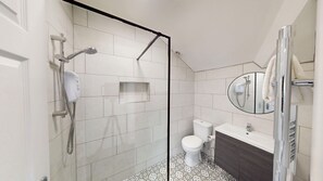 Full Bathroom 2:
One of two modern bathrooms, featuring a sleek electric shower, contemporary sink and toilet. Complimentary shampoo and body wash are provided for a fresh, hotel-style experience.
