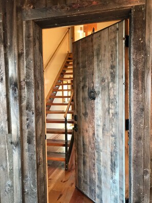 A wooden door with a metal latch and a metal handle, leading to a wooden staircase with metal railings. - Oso Verde Ranch, a natural oasis, is located just a mile from downtown Mancos (Mancos)