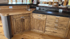 A kitchen with wooden cabinets, a granite countertop, and a sink. - Oso Verde Ranch, a natural oasis, is located just a mile from downtown Mancos (Mancos)