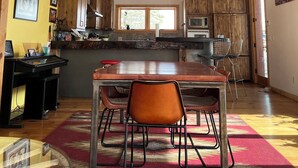 A spacious kitchen with wooden cabinets, a large island, and a red hanging light fixture. - Oso Verde Ranch, a natural oasis, is located just a mile from downtown Mancos (Mancos)