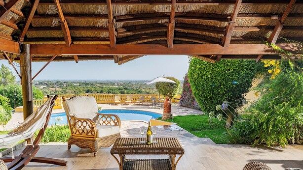 A covered outdoor seating area with a pool, wicker furniture, and a view of the landscape. - Charming home with panoramic sea views, close to Aquashow, Airport & beaches (Almancil)