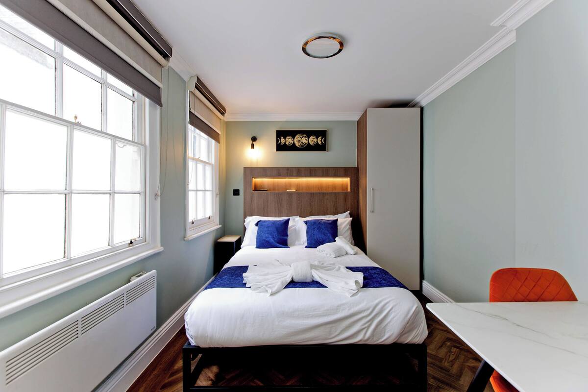 A hotel room with a bed, a table, and a chair.