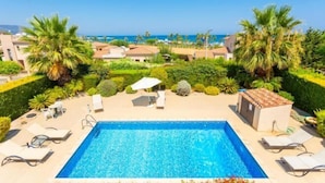 A swimming pool with lounge chairs and a view of the sea. - Villa Fortuna (Polis)