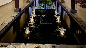 A corridor with a central water feature, wooden pillars, and traditional doors. - The Nature Palace Villa (Uragasmanhandiya)