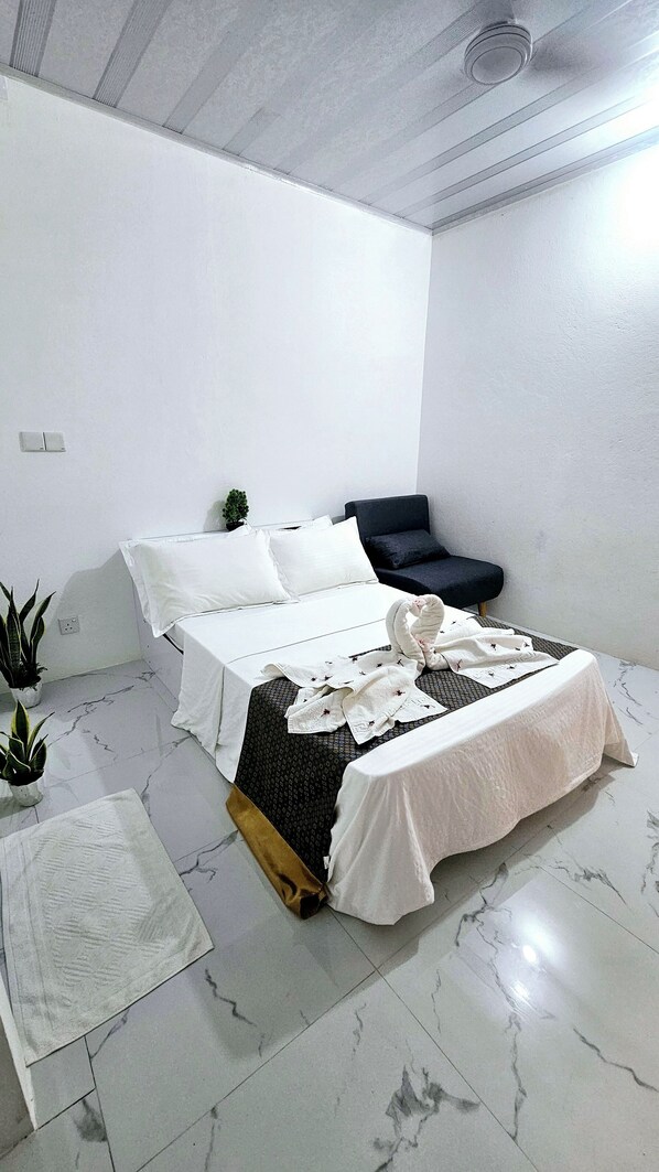 A bedroom with a bed, a small sofa, and a potted plant. - Blue Haven Retreat (Thulusdhoo Island)