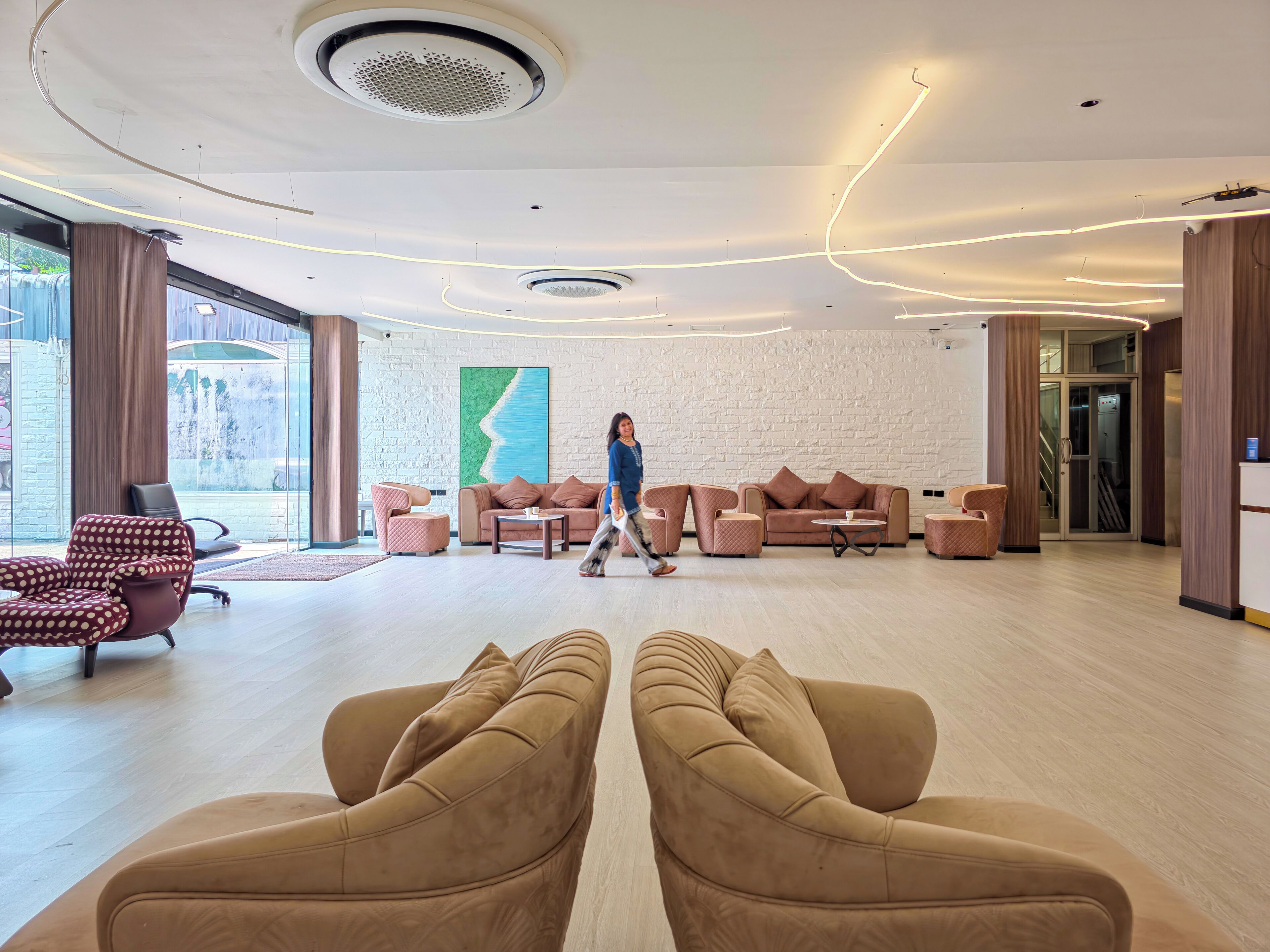 A modern interior with a central seating area, a large window, and a visible ceiling design.