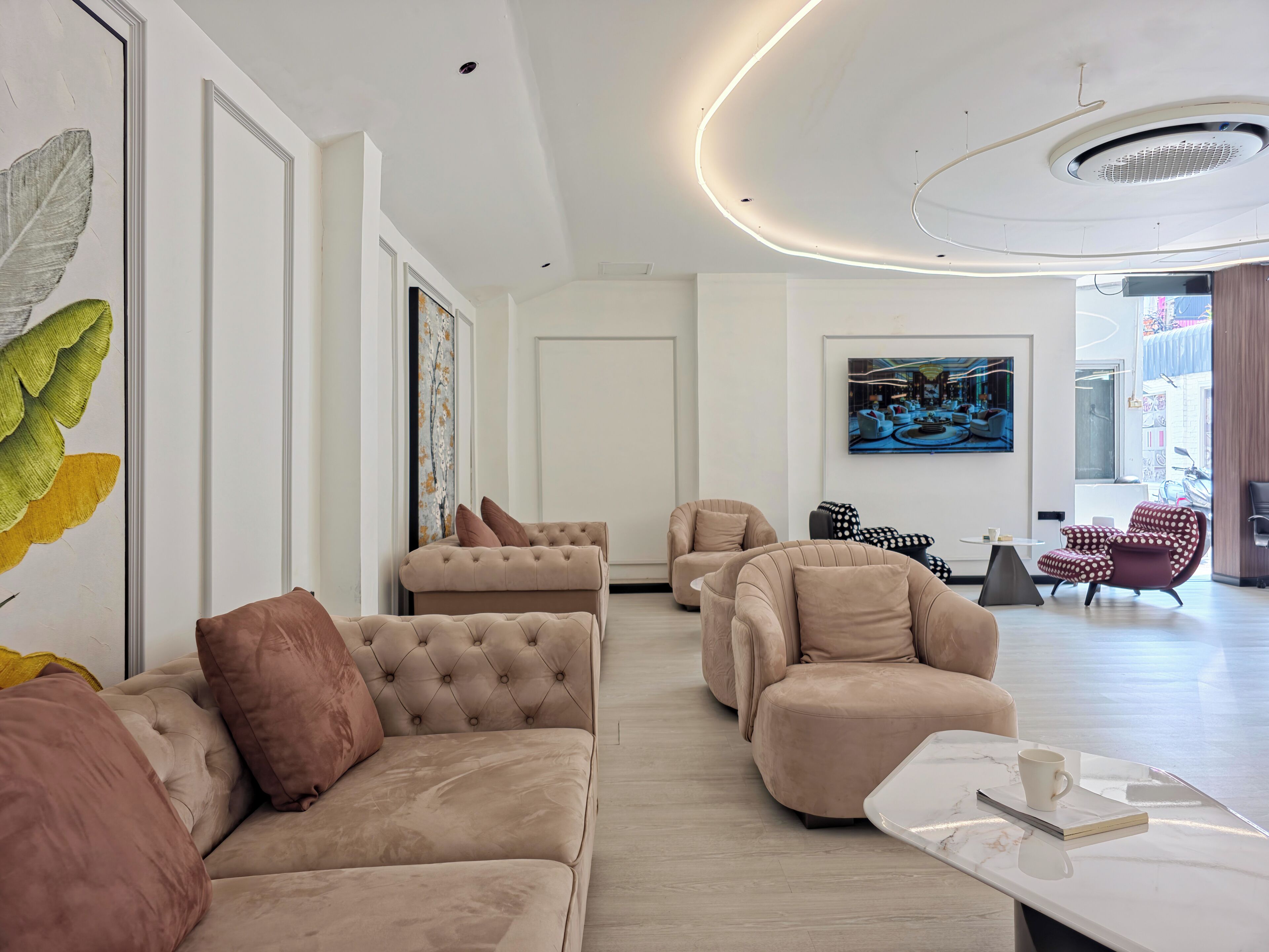 A modern living room with a sofa set, a coffee table, and artwork on the walls.
