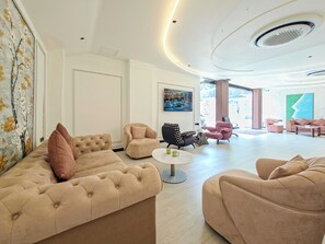 Eine moderne Hotellobby mit einem großzügigen Sitzbereich, einem Couchtisch und Kunstwerken an den Wänden.