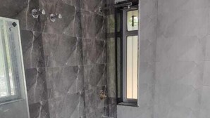 A bathroom with a marble wall, a sink, and a window. - Treebo Sai Village Suites (Gurugram)