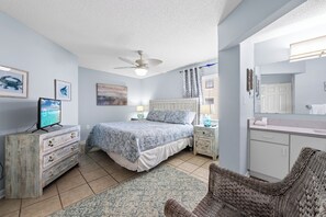 A bedroom with a bed, dresser, and a large mirror. - Four Winds 301 (Orange Beach)