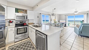 A modern kitchen with stainless steel appliances, a central island, and a view to the outside. - Four Winds 301 (Orange Beach)