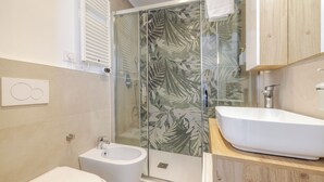 A modern bathroom with a glass shower enclosure, a white sink, and a bidet. - NEW private room with bathroom and balcony 20 minutes from Milan (room number2) (Trezzano sul Naviglio)