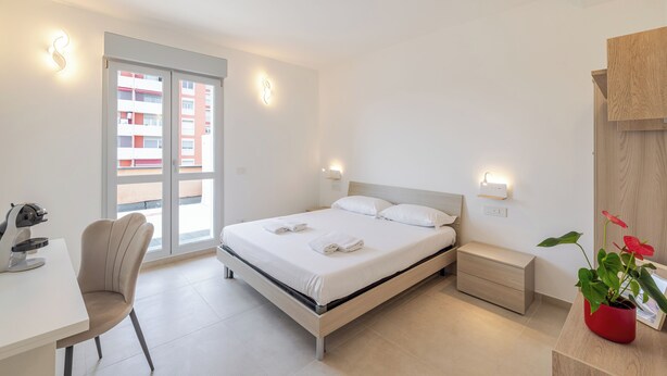 A modern bedroom with a bed, bedside table, chair, and a desk. - NEW private room with bathroom and balcony 20 minutes from Milan (room number2) (Trezzano sul Naviglio)