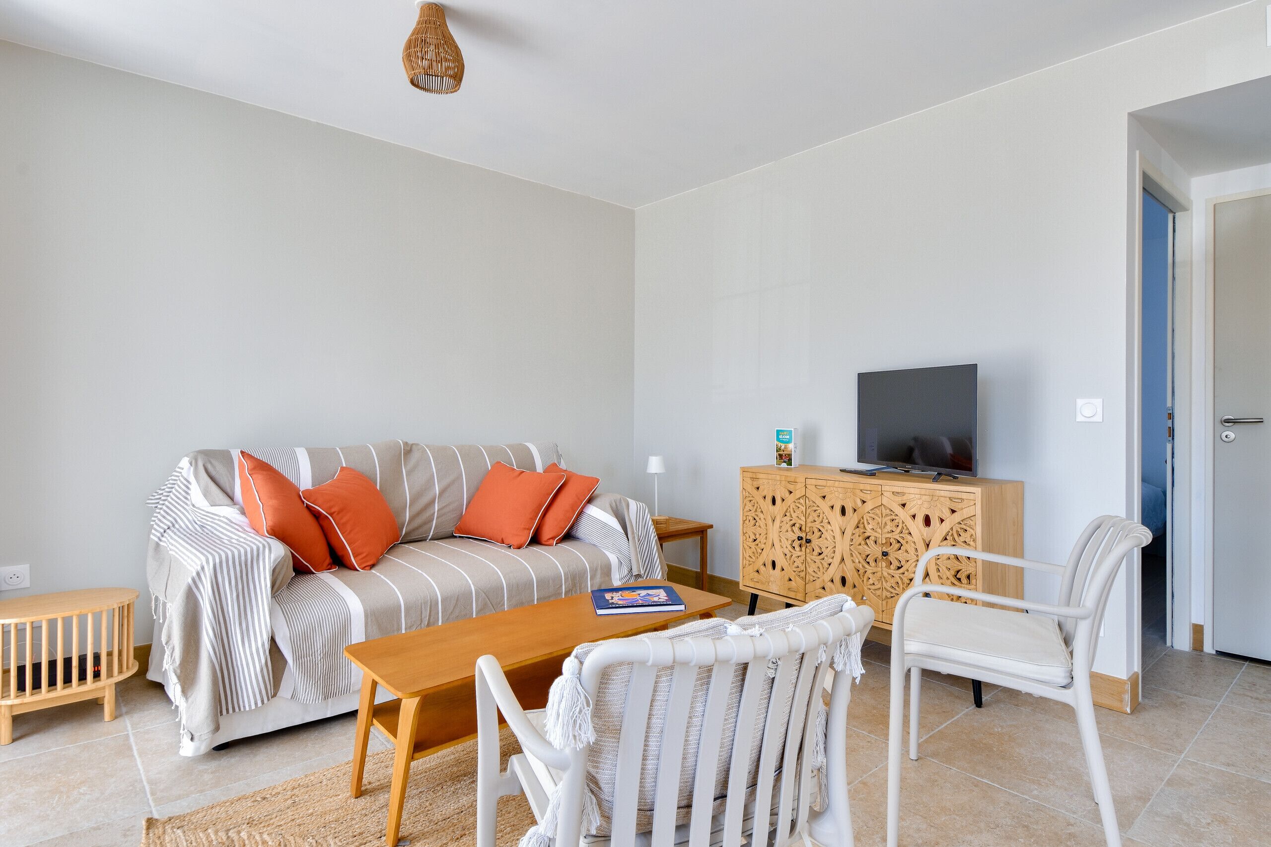 A living room with a sofa, a coffee table, a TV, and a cabinet.