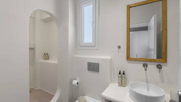 Un baño con bañera, lavamanos, espejo y ventana.