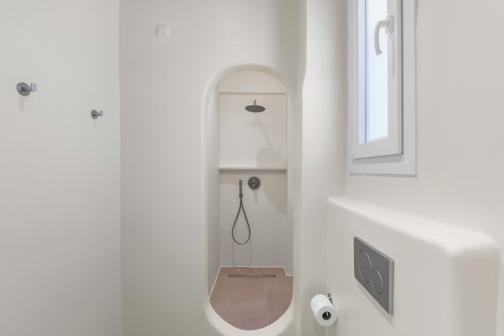 Une salle de bain équipée d’une douche, de toilettes et d’un miroir fixé au mur.