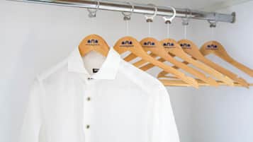 A white shirt hanging on a wooden hanger with a logo.